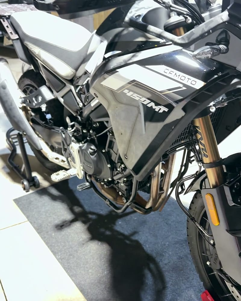 CFMOTO 450MT adventure bike cleaned up — tank badge, crash bars and gold forks in the sun