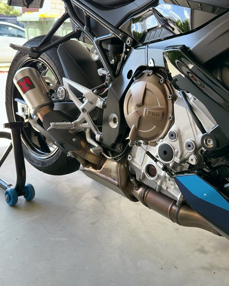 BMW S1000R engine cases and exhaust after cleaning, bike up on a paddock stand