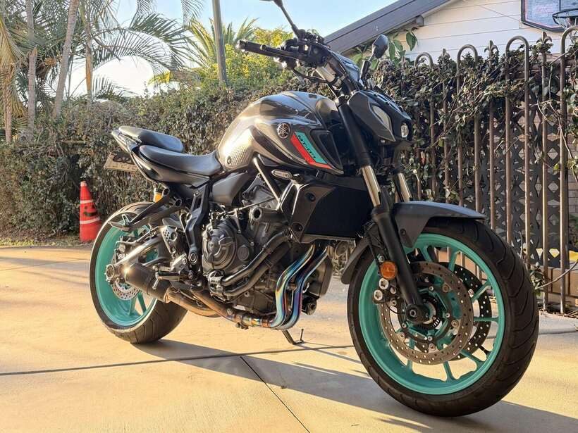 Yamaha MT-07 with teal wheels, freshly detailed in golden afternoon light