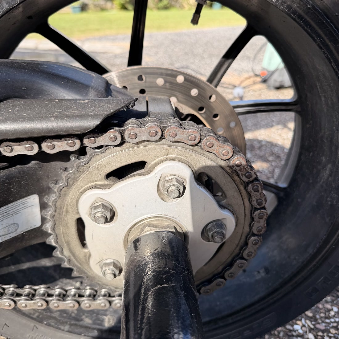 A Ducati 848 chain and sprocket before detailing — dusty, with rust-brown chain links