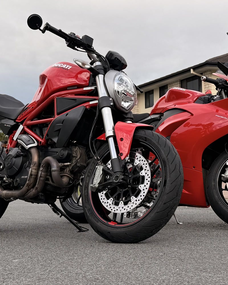 Ducati Monster 659 and Panigale V2 side by side on the street, both freshly detailed